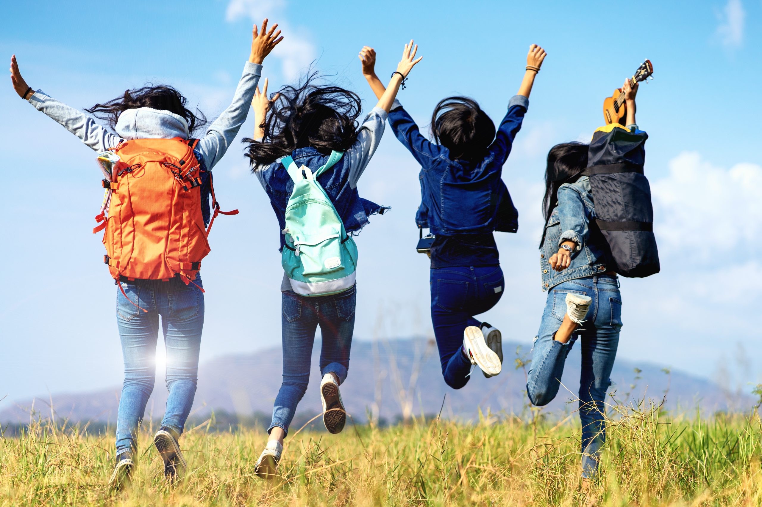 Trekking holiday concept.Four women are trekking in the mountains with backpack,tent,hiking equipment.